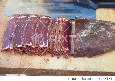 turkish meat pasturma on a chopping board , dried meat on a plate turkish meat pasturma on a chopping board , dried meat on a plate 116285161