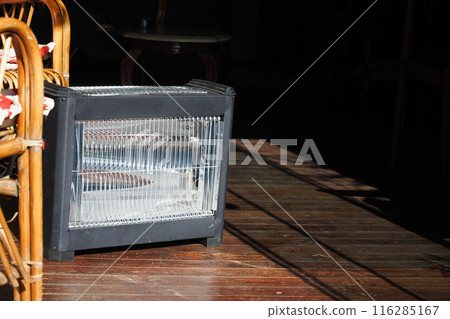 Modern electric infrared heater in living room, closeup Modern electric infrared heater in living room, closeup 116285167