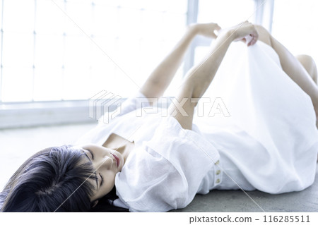 A young woman in a white dress lying down A young woman in a white dress lying down 116285511