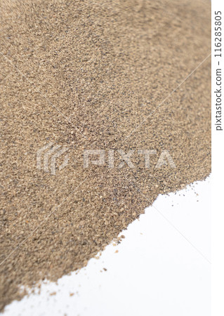 Spilled ground black pepper spicy seasoning on a white background Spilled ground black pepper spicy seasoning on a white background 116285805