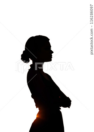 Silhouette of a woman with her arms crossed looking up at the sky 116286097