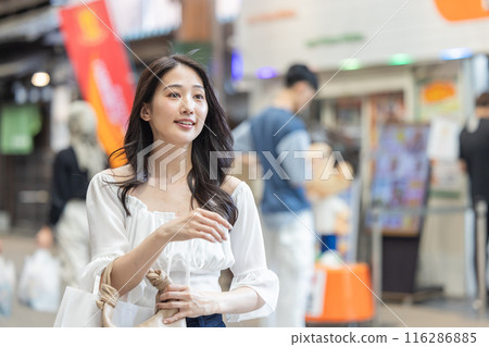 Young woman walking through a shopping street Young woman walking through a shopping street 116286885