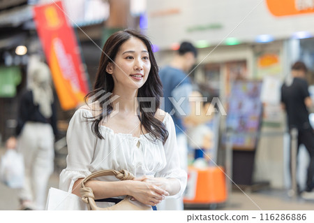 Young woman walking through a shopping street 116286886
