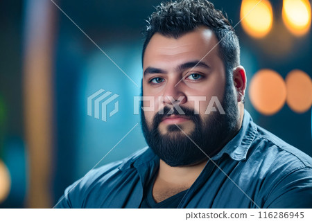 A man with a beard and a blue shirt. 116286945