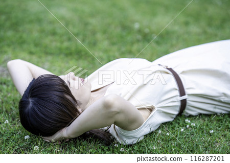 一個女人躺在新鮮的綠色草地上 116287201