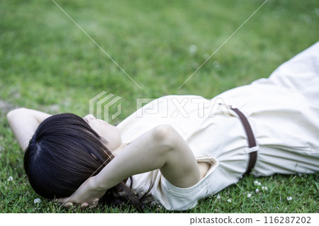 一個女人躺在新鮮的綠色草地上 116287202