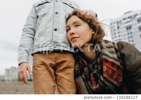 Satisfied mother smiles in the arms of her son. 116288127