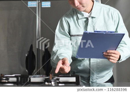 Asian man in work clothes inspecting the kitchen 116288396