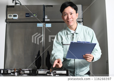 Asian man in work clothes inspecting the kitchen 116288397