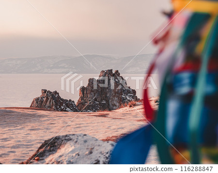 A vibrant, blurry bundle of colorful ribbons frames the view of a dramatic rock formation on Olkhon Island in Siberia. A vibrant, blurry bundle of colorful ribbons frames the view of a dramatic rock formation on Olkhon Island in Siberia. 116288847