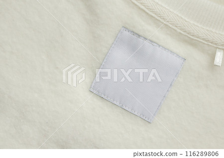 Blank white laundry care clothes label on fabric texture background 116289806