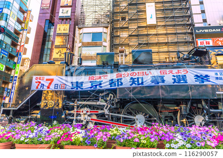 Tokyo cityscape in Japan in July. Shimbashi Station (Hibiya Exit) and the steam locomotive at Shimbashi Steam Locomotive Square. A banner for the Tokyo gubernatorial election... = 3rd Tokyo cityscape in Japan in July. Shimbashi Station (Hibiya Exit) and the steam locomotive at Shimbashi Steam Locomotive Square. A banner for the Tokyo gubernatorial election... = 3rd 116290057