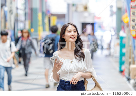 Casual business woman walking through a shopping street Casual business woman walking through a shopping street 116290063
