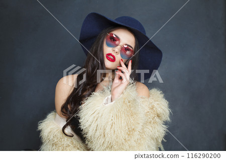 Posing fashion model woman with long dark wavy hairstyle and red lips make-up  116290200