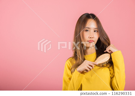 Young beautiful Asian woman upset with a comb and problem hair, Portrait female shocked suffering from hair loss problem, studio shot isolated on pink background, medicine health concept 116290331