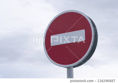 A road sign indicating no entry is clearly visible with a background of a cloudy sky A road sign indicating no entry is clearly visible with a background of a cloudy sky 116290887