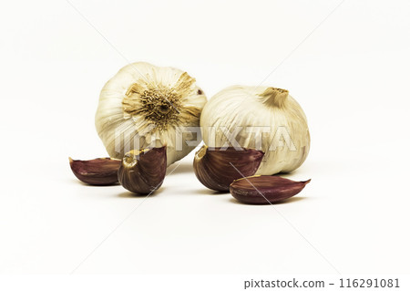 Two heads and cloves of garlic on a white background. On a white background lie heads and raw garlic cloves Two heads and cloves of garlic on a white background. On a white background lie heads and raw garlic cloves 116291081