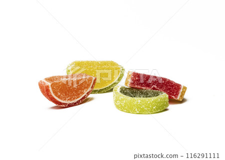 On a white background there are multicolored wedges of marmalade. Multicolored wedges of marmalade in sugar on a white background 116291111