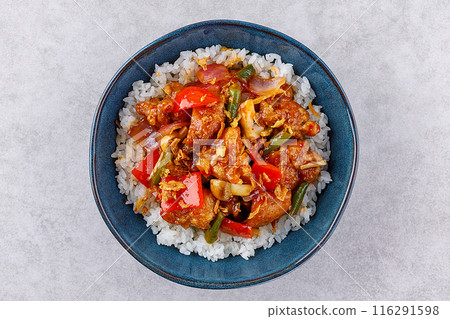 Rice with pork and vegetables in a sweet and sour sauce on a grey background, for a restaurant menu or food delivery 116291598