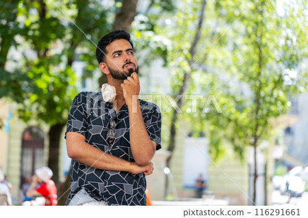 Thoughtful pensive puzzled Indian man with pensive expression pondering a solution doubting question Thoughtful pensive puzzled Indian man with pensive expression pondering a solution doubting question 116291661
