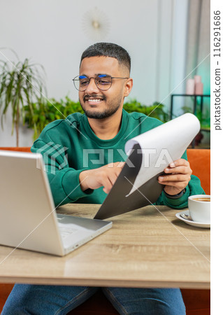 Happy man freelancer work with documents from home, analyzing information prepare financial report 116291686