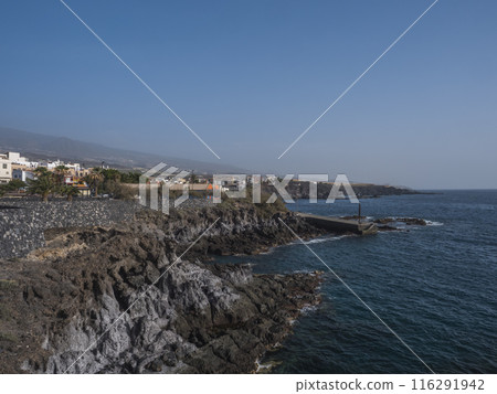 Views of rocky coast and Alcala village with traditional architecture houses, small tranquil cove with beach and pier Tenerife, Canary Islands, Spain. Views of rocky coast and Alcala village with traditional architecture houses, small tranquil cove with beach and pier Tenerife, Canary Islands, Spain. 116291942