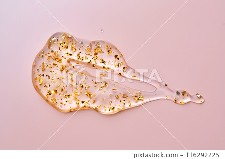 Cosmetic serum with 24k gold on a pink background. Cosmetic serum with 24k gold on a pink background. 116292225