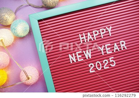 Happy New Year 2025 letters with LED cotton balls decoration top view on purple background 116292279