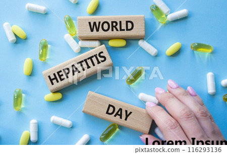 World Hepatitis Day symbol. Concept words World Hepatitis Day on wooden blocks. Beautiful blue background with pills. Doctor hand. Healthcare and World Hepatitis Day concept. Copy space. 116293136