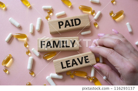 Paid Family Leave symbol. Concept words Paid Family Leave on wooden blocks. Beautiful pink background with pills. Doctor hand. Healthcare and Paid Family Leave concept. Copy space. 116293137