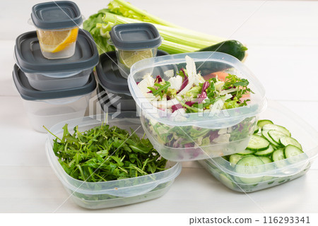 A stack of plastic containers and raw vegetables on the table. Storage for vegetables and fruits in plastic containers 116293341