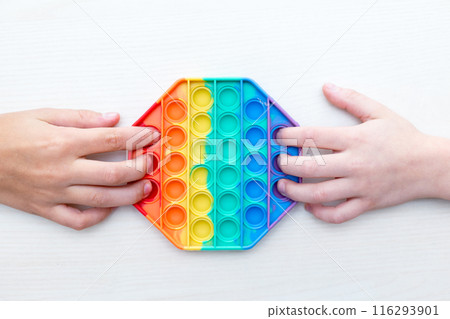 Childrens hands playing with sensory pop it toy. Sensory toy develops fine motor skills,antistress 116293901