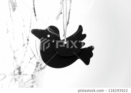 Closeup of a Halloween black felted raven on white background with copy space for text. 116293922