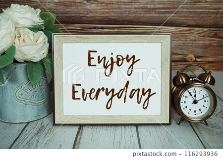 Enjoy Everyday text message with alarm clock on wooden background, Inspriation and motivationa quote Enjoy Everyday text message with alarm clock on wooden background, Inspriation and motivationa quote 116293936
