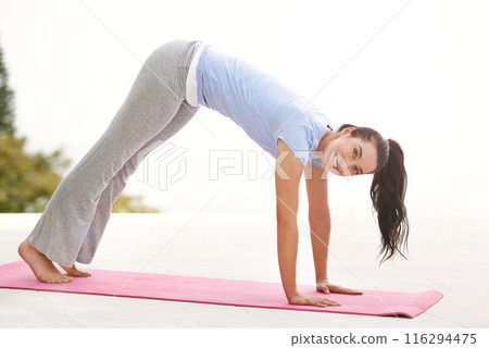 Yoga, pose and portrait of woman in downward dog with exercise for fitness and holistic wellness. Training, arms and legs in workout with girl on beach in summer and strong resilience for challenge 116294475