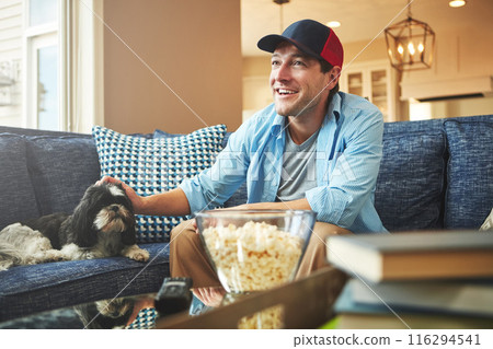 Happy, man and dog with popcorn in home on sofa with watching sports game, challenge and fun. Living room, couch and excited or smile with bonding for tournament, competition and entertainment 116294541