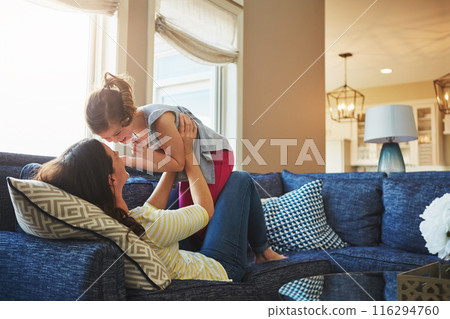 Love, happy and mother embracing her child while relaxing on sofa in the living room of their home. Happiness, bonding and young mom hugging her laughing daughter with care in their family house 116294760