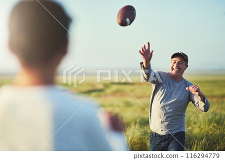 Kid, man and throw with football on grass field for outdoor sports, teaching and child development. Happy, dad and smile with son in nature for practice, exercise and bonding together on fathers day Kid, man and throw with football on grass field for outdoor sports, teaching and child development. Happy, dad and smile with son in nature for practice, exercise and bonding together on fathers day 116294779