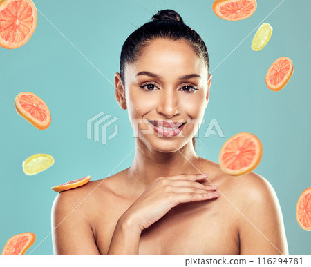 Fruit, skincare and portrait of woman on blue background for beauty, facial and salon treatment. Lemon, grapefruit and face of person for vitamin c, wellness and health in studio for dermatology 116294781