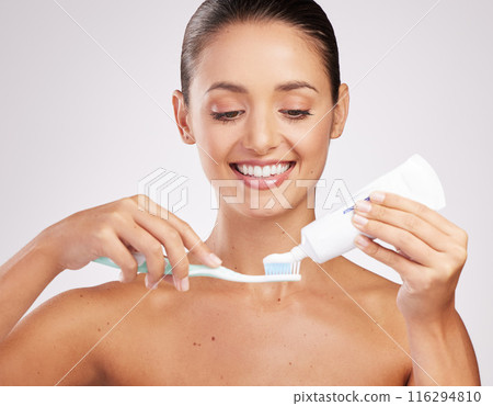 Woman, toothpaste and brushing teeth for hygiene in studio with whitening results and oral health. Female person, dental product and brush with cleaning mouth for fresh breath by white background 116294810