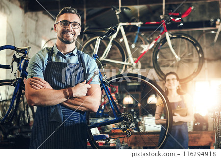 Man, portrait and arms crossed at work in bicycle repair shop or maintenance garage. Bike, mechanic and service with a professional handyman for startup, small business and workshop for fixing Man, portrait and arms crossed at work in bicycle repair shop or maintenance garage. Bike, mechanic and service with a professional handyman for startup, small business and workshop for fixing 116294918