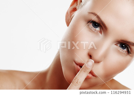 Woman, portrait and secret in studio for beauty, skincare and wellness with mockup space. Model girl, hand and privacy by white background for treatment, dermatology and confidential for cosmetics 116294931