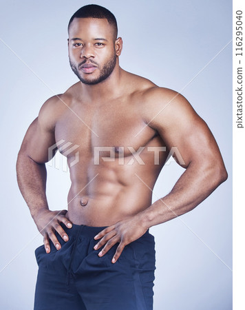 Black man, serious and shirtless in studio with fitness for healthy body, portrait and muscle power with confidence. Bodybuilder, athlete and pride with wellness and arm strength on blue background Black man, serious and shirtless in studio with fitness for healthy body, portrait and muscle power with confidence. Bodybuilder, athlete and pride with wellness and arm strength on blue background 116295040