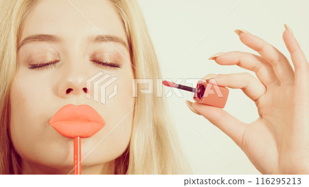 Woman applying lipstick or lip gloss 116295213