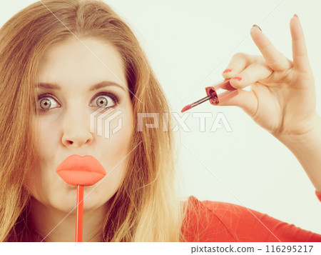 Woman applying lipstick or lip gloss 116295217