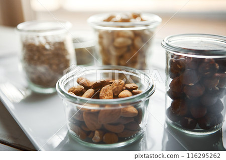 Bowls, nuts and seeds on plate, kitchen and hazelnut for nutrition, health and table with diet for wellness. Cashew, almond and storage in glass container for meal prep with food in morning at house Bowls, nuts and seeds on plate, kitchen and hazelnut for nutrition, health and table with diet for wellness. Cashew, almond and storage in glass container for meal prep with food in morning at house 116295262