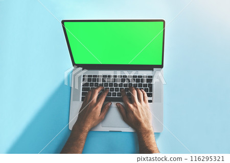 Green screen, laptop and hands of man in studio top view for social media, email or online communication on blue background. Mockup, keyboard and freelance editor with remote work, editing or project 116295321
