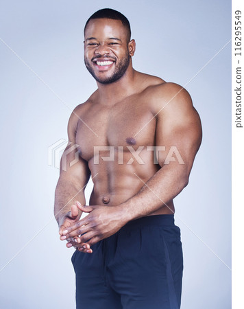Black man, portrait and shirtless in studio with fitness for healthy body, happy and muscle power with confidence. Bodybuilder, athlete and smile with wellness and arm strength on blue background Black man, portrait and shirtless in studio with fitness for healthy body, happy and muscle power with confidence. Bodybuilder, athlete and smile with wellness and arm strength on blue background 116295549