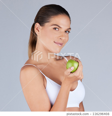 Portrait, woman and apple smiling for healthy diet, fitness and nutrition in grey studio background. Wellness, female person and fruit happy for organic meal, snack or vegan eating with vitamins 116296408