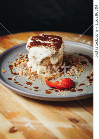 Delectable Tiramisu Served on a Ceramic Plate Garnished With Strawberry and Cocoa 116296504